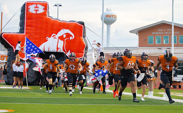 The Hutto football team crashes through a Texas-sized Hippo banner.